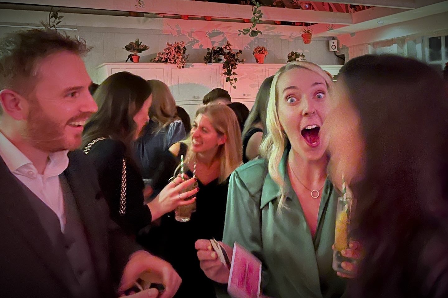 Close-up magic performance at a corporate event, with guests smiling and reacting in amazement to Richard Symes’ sleight of hand entertainment.