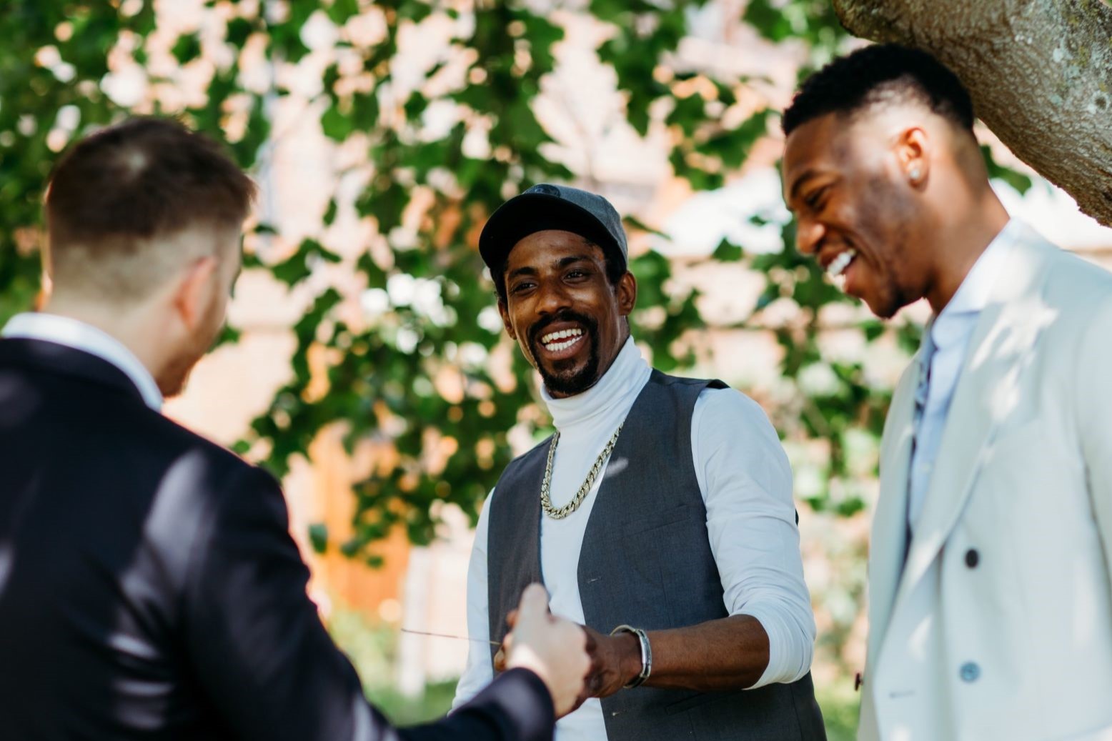 Two male guests impressed and looking at magician Richard Symes after impossible card trick at Essex event