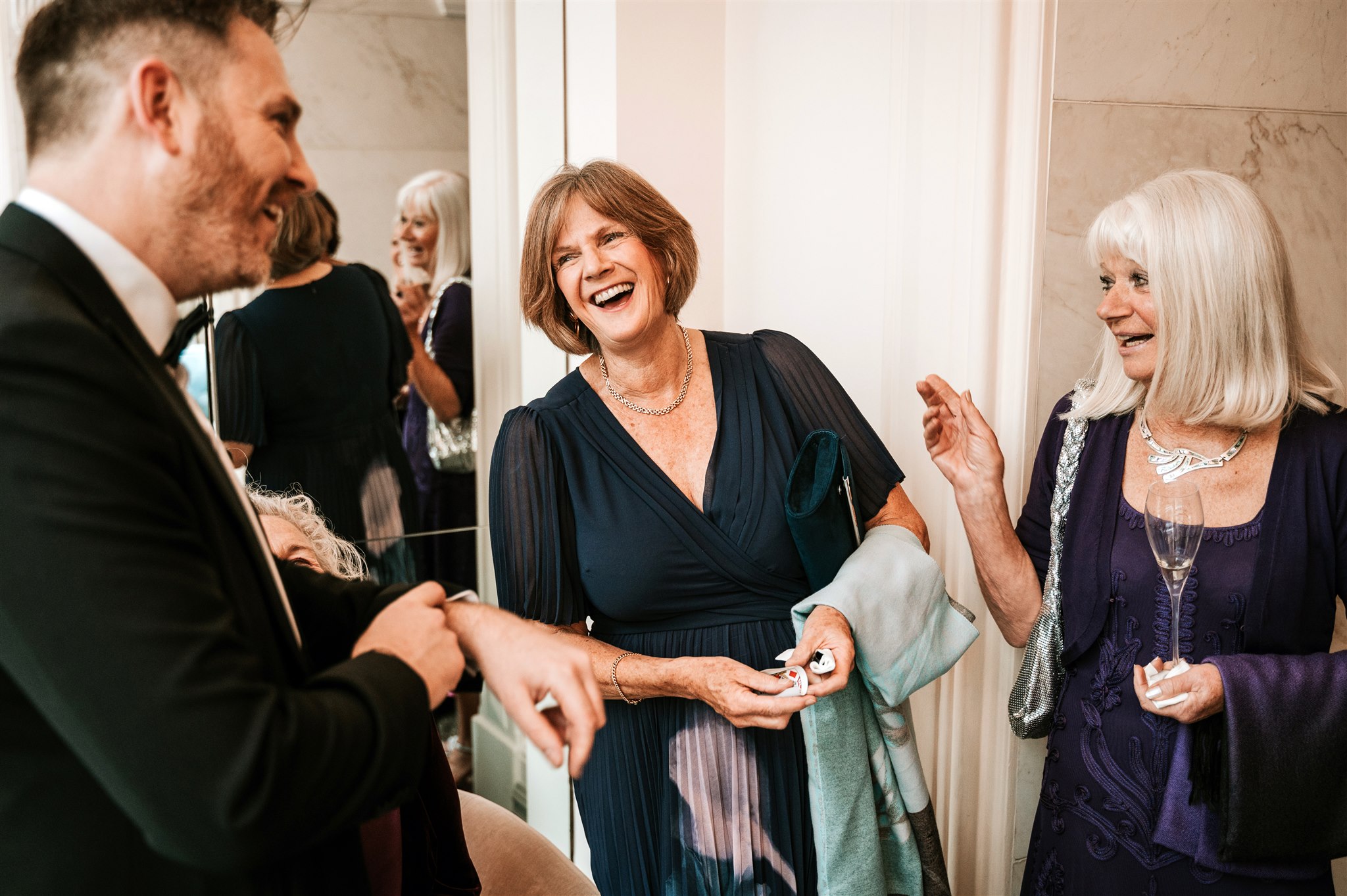 Wedding magician Richard Symes performing close-up card magic entertaining guests with laughter at a wedding reception in the UK