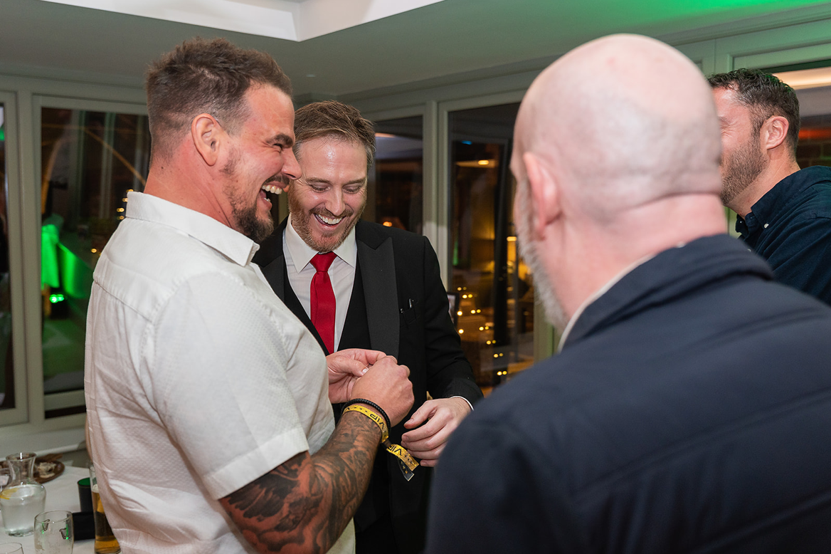 Guests looking amazed during sleight of hand magic at an adult birthday party