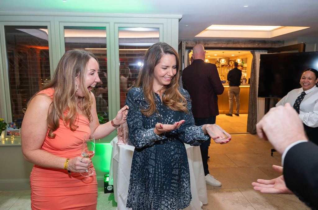Close up magician performing interactive card magic for birthday girl at milestone birthday party