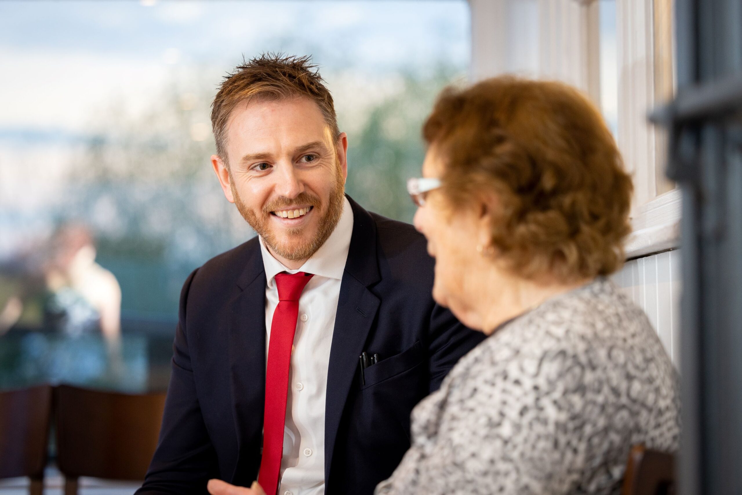 Magician chatting with guest during a 60th birthday party between performances