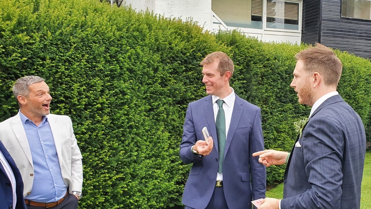 Garden Party Magic trick in the afternoon. 3 gentlemen enjoying the magic.