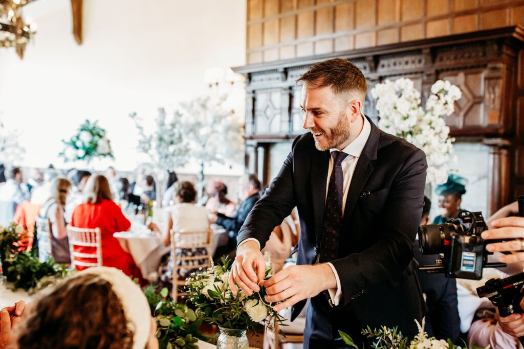 Magician performing at a wedding reception for the family at the top table. Image shows only the magician holding magic trick.