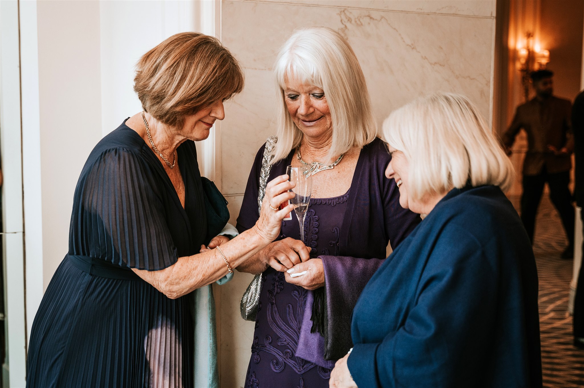Three guests at a 60th birthday party looking a selected card ensuring the magician is not looking.