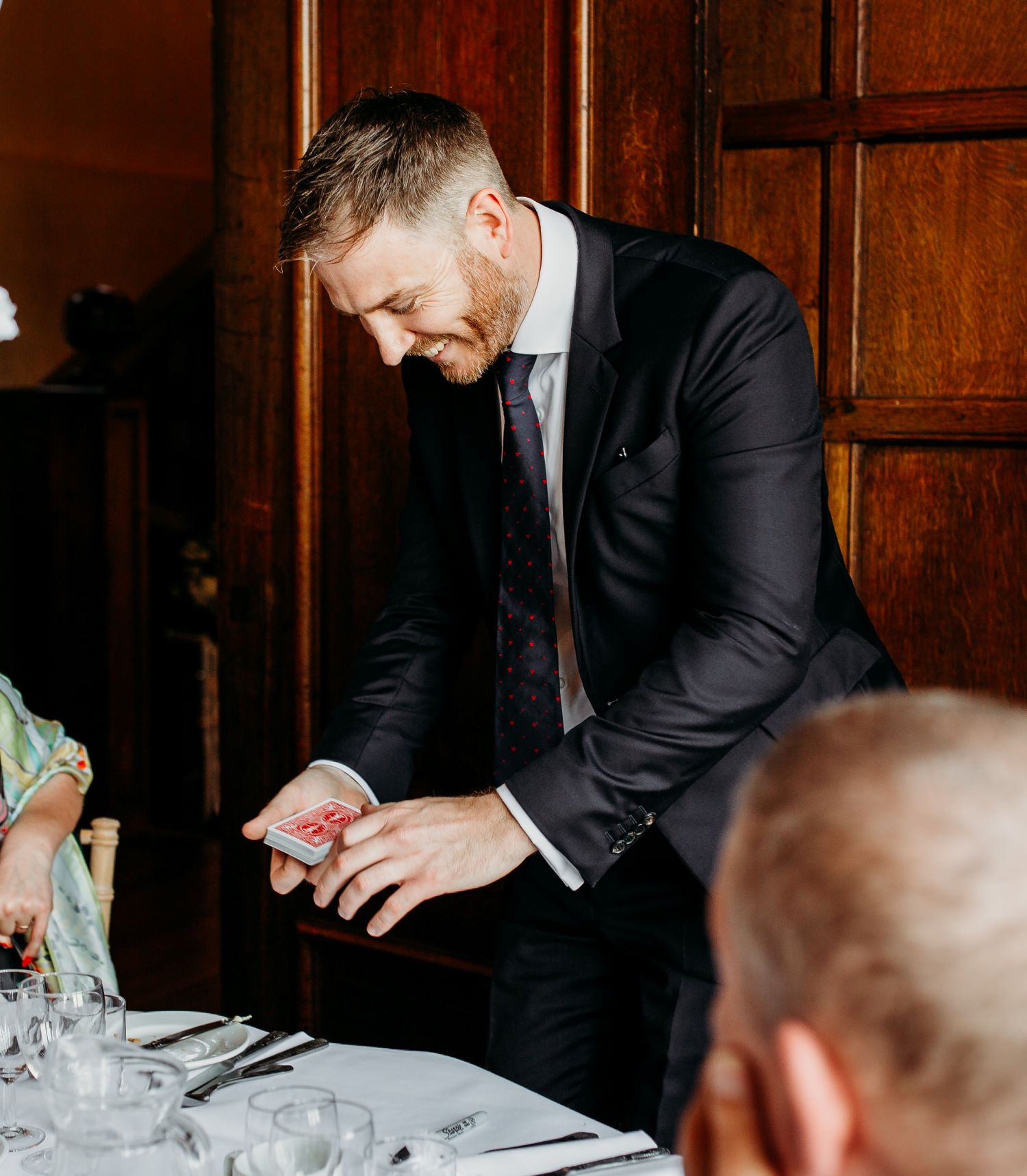 Close up magician holding a deck of cards ready to perform at a wedding