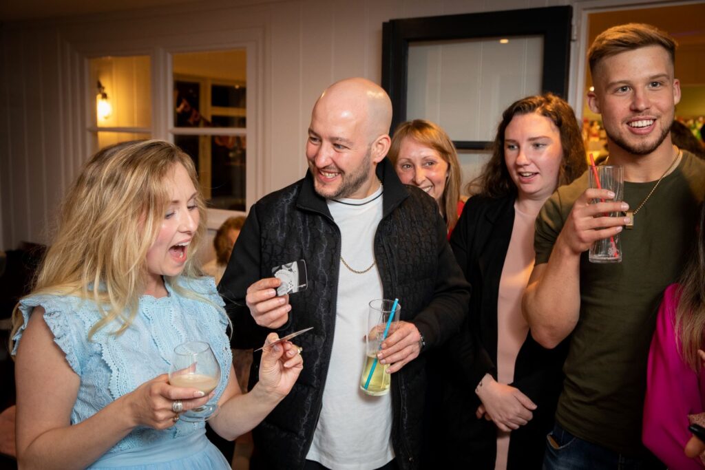 Birthday girl reacting with amazement while friends watch magic