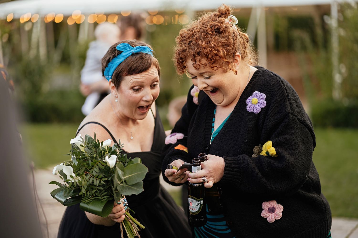 Two wedding guests amazed by a card trick during drinks reception magic