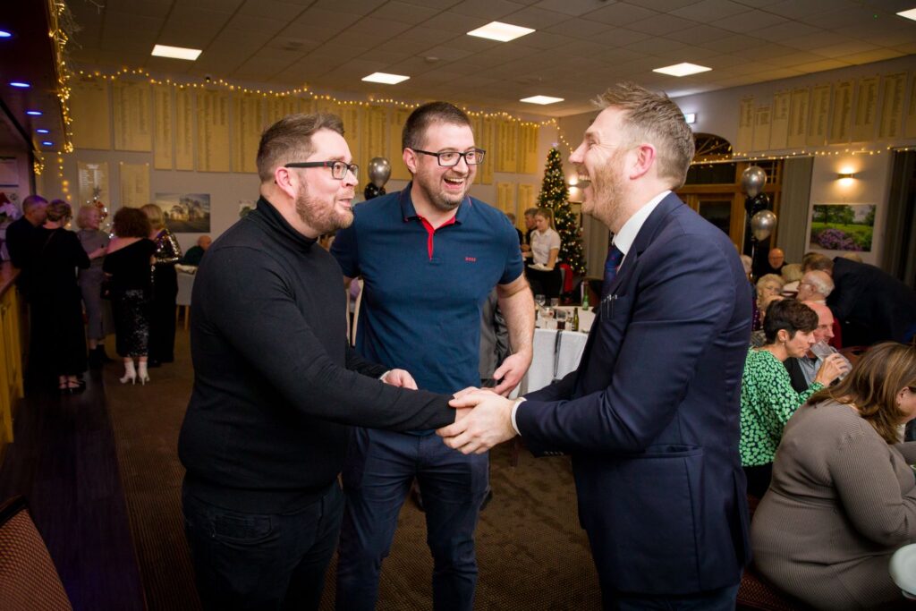 Corporate guests shaking hands with magician at Christmas party
