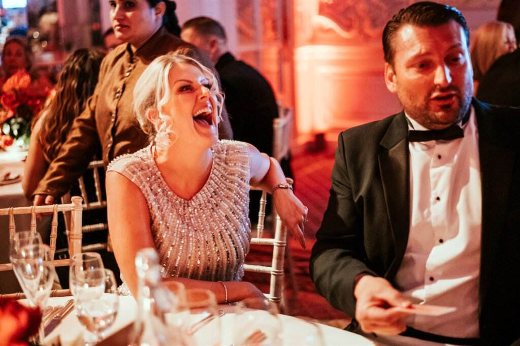 Colleagues gather around mid performance, smiling as the magic unfolds during the event.