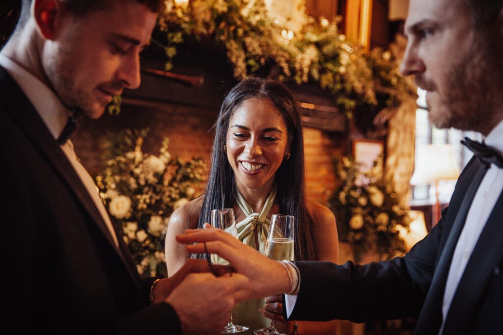 Close up magician performing for two guests during a corporate Christmas party