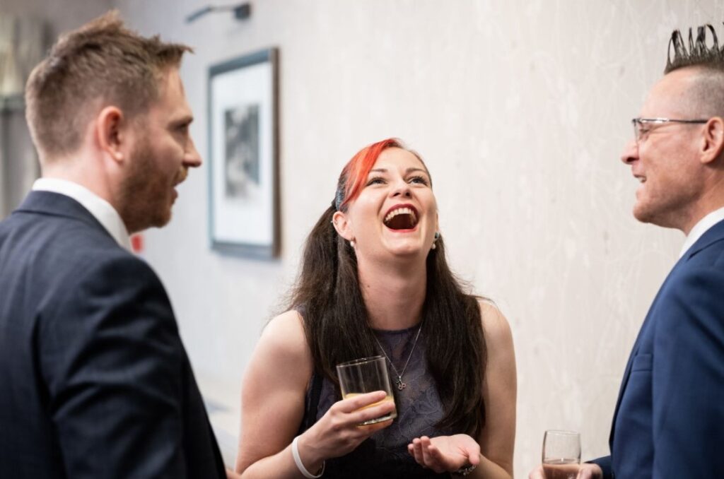Close up magician entertaining guests at summer party with laughter and surprise