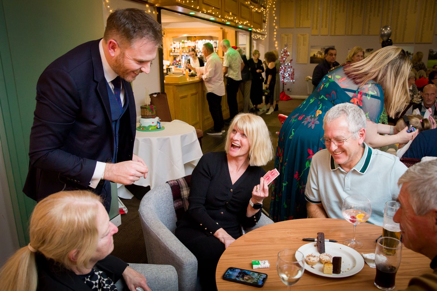 Table of guests watching close-up magician during corporate Christmas dinner