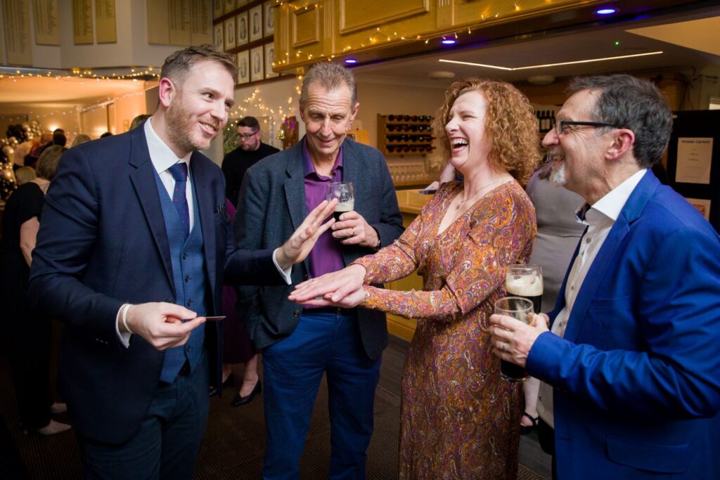 Corporate Christmas party guests laughing during live magic performance