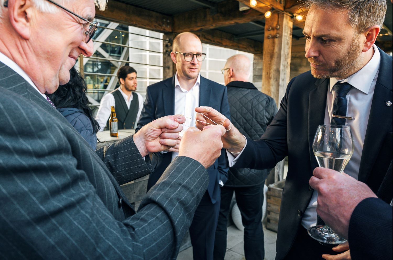 Corporate guests watching sleight of hand magic during Christmas function