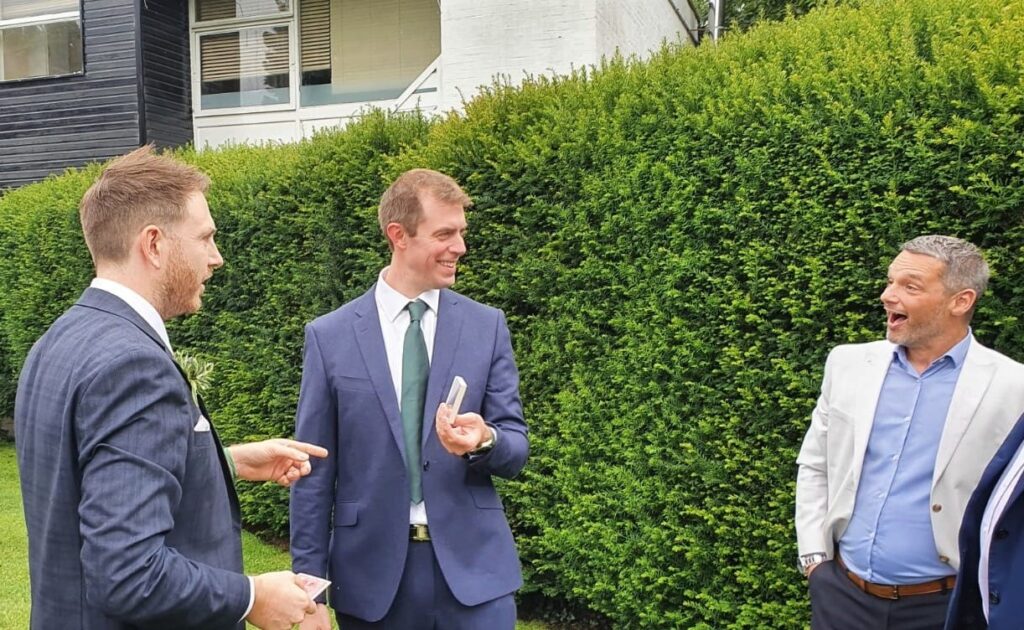 Guests reacting with surprise to close up magic at summer party