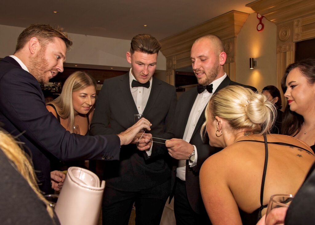 Groups of guests watching close-up magic at London corporate venue